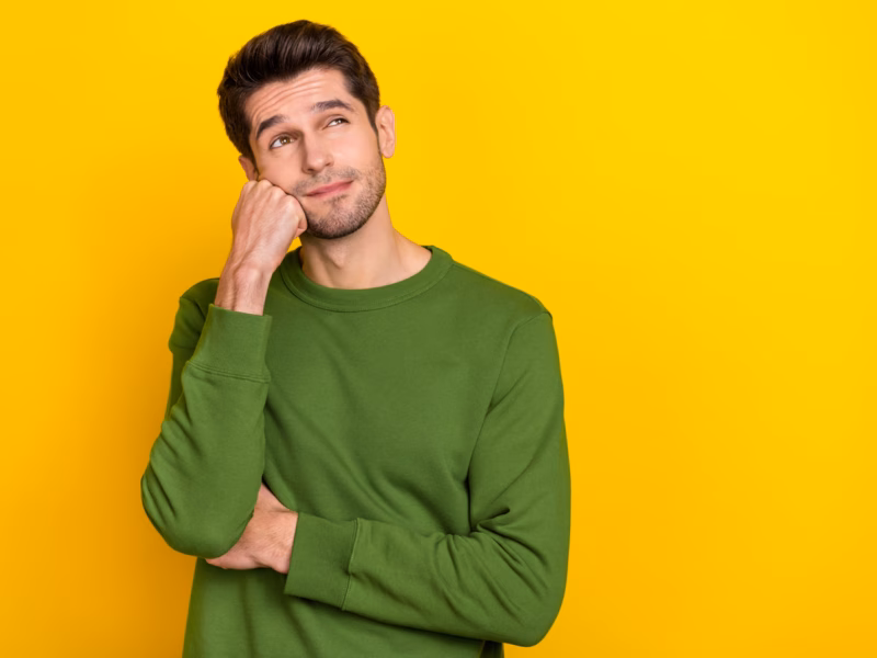 A 30ish man wearing a green sweater and wondering when he should replace his HVAC system