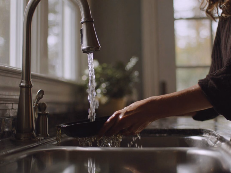 Photo of a Charlottesville-area home kitchen sink showing slow-draining water and a drain screen, illustrating early signs of grease buildup common in local households near downtown Charlottesville.