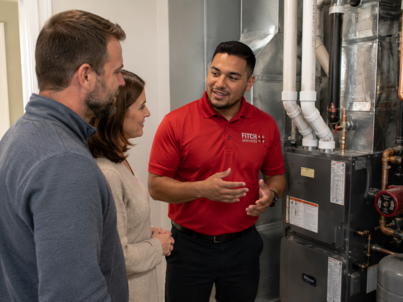Homeowners discussing a new heating system installation with a Fitch Services technician near Charlottesville, VA.